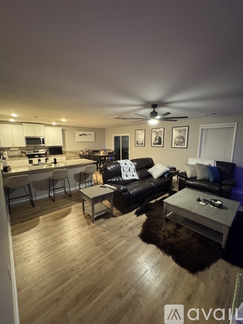 A living room with a black couch and a coffee table.