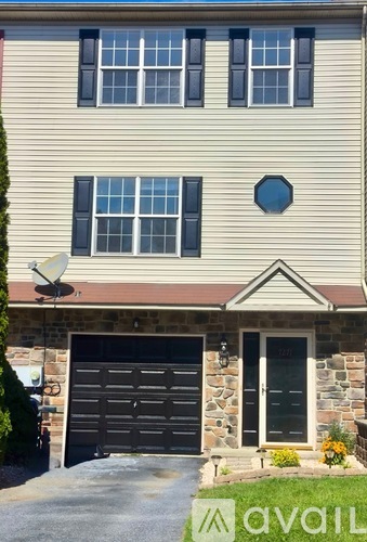 A house with a garage and a satellite dish on the roof.