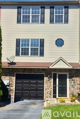 A house with a garage and a satellite dish on the roof.