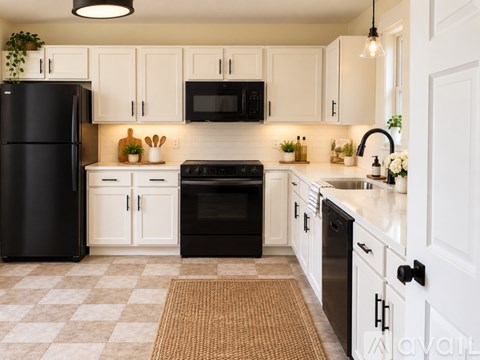 A kitchen with black appliances and white cabinets.