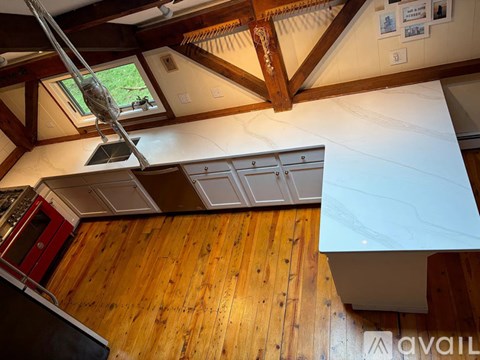 A kitchen with a wooden floor and a white counter top.