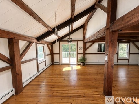 A spacious room with wooden beams and flooring.