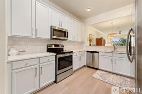 A kitchen with white cabinets and stainless steel appliances.