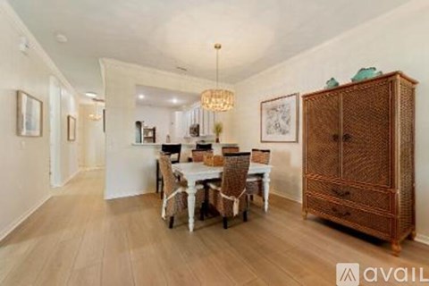 A dining room with a wooden floor and a white table with chairs.