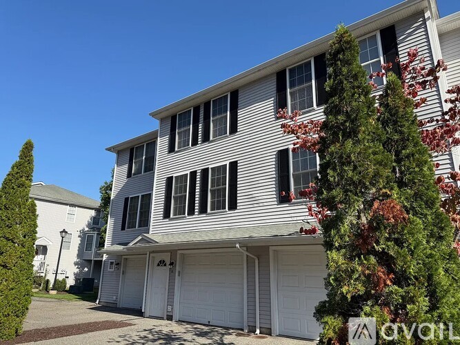 A two-story house with a garage and a driveway.