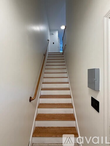 A staircase with wooden steps and a metal handrail.