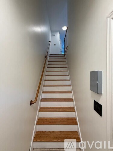 A staircase with wooden steps and a metal handrail.