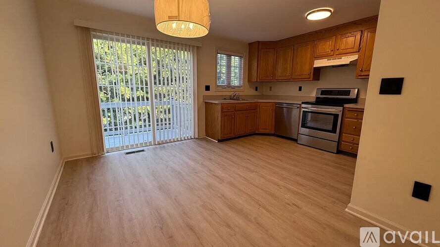 A kitchen with wooden cabinets and a stainless steel oven is available for rent.