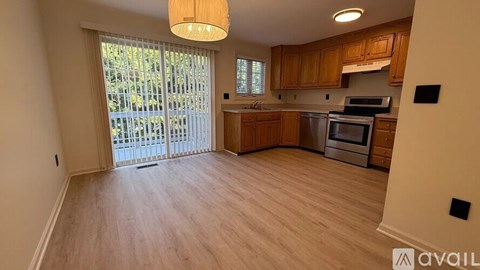 A kitchen with wooden cabinets and a stainless steel oven is available for rent.