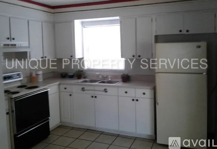 A kitchen with white cabinets and a black stove top oven.