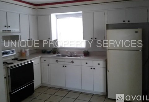 A kitchen with white cabinets and a black stove top oven.