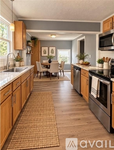 A kitchen with wooden cabinets and a dining table with chairs.