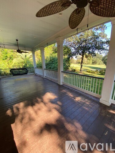 A porch with a fan and a view of the trees.
