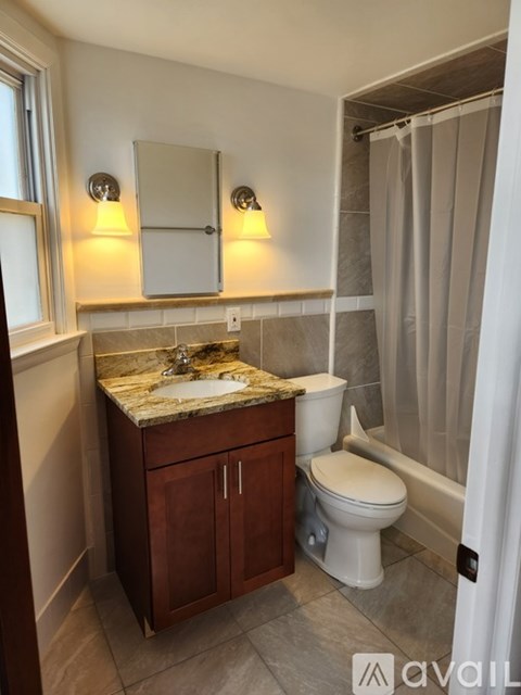 A bathroom with a sink, toilet and a shower.