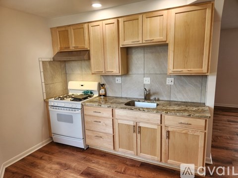 A kitchen with wooden cabinets and a marble countertop.