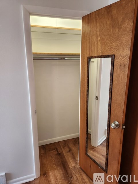 A wooden door with a mirror on the right side.