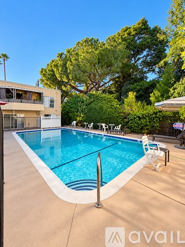 A swimming pool surrounded by trees and a building.