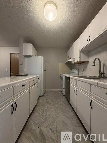 A kitchen with white cabinets and a sink.