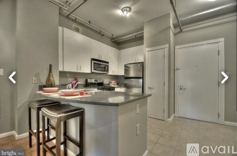 A kitchen with a bar stool in front of it.