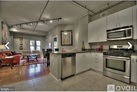 A kitchen with stainless steel appliances and white cabinets.