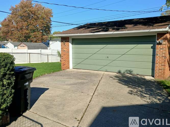 A garage with a green door is situated in front of a house.