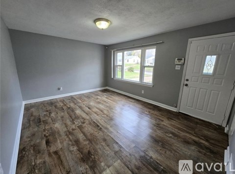 A room with wooden flooring and a white door.