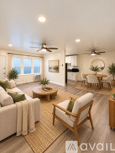 A living room with a couch, chairs, and a dining table.
