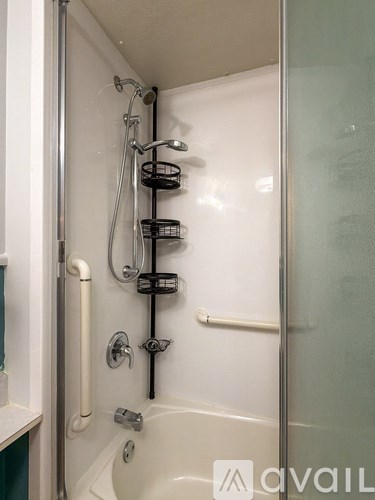 A white bathtub with a shower head and hand held shower.