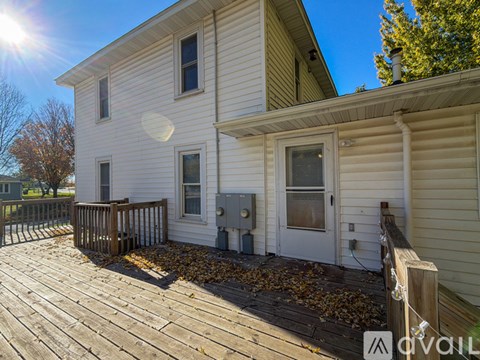 A house with a wooden deck and a utility box on the side.