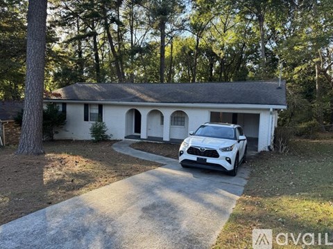 A white house with a car parked in front.