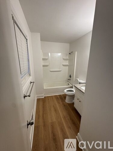 A bathroom with a toilet, sink, and a window.