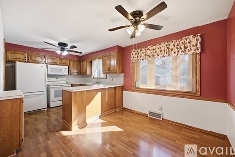 A kitchen with wooden cabinets and a white refrigerator.