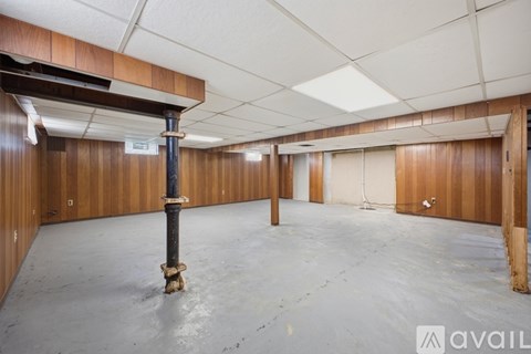 A large empty room with wooden walls and a concrete floor.