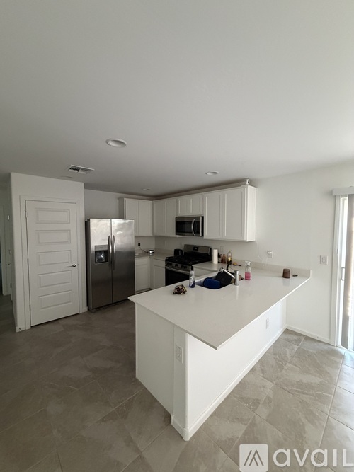 A kitchen with a white island and a refrigerator.