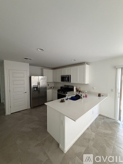 A kitchen with a white island and a refrigerator.