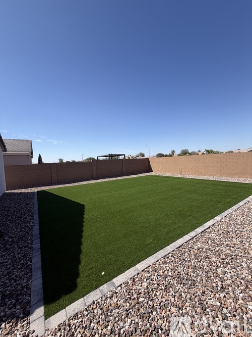 A rooftop garden with a grassy area and a stone border.