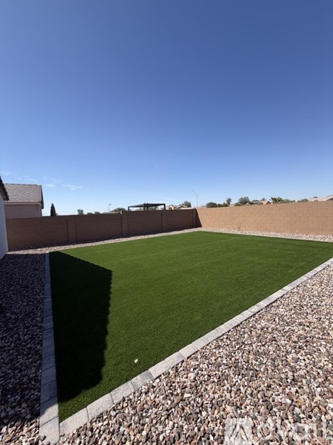 A rooftop garden with a grassy area and a stone border.