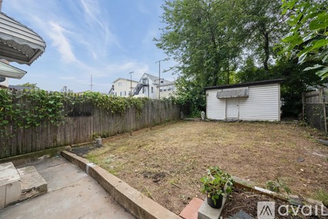 A backyard with a shed, a fence, and a small garden.