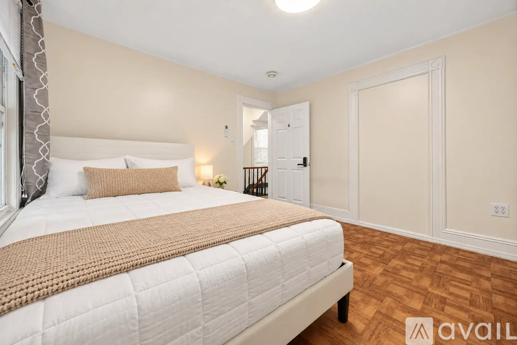 A bedroom with a large bed and a wooden floor.