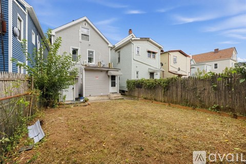 A backyard with a fence and a house in the background.