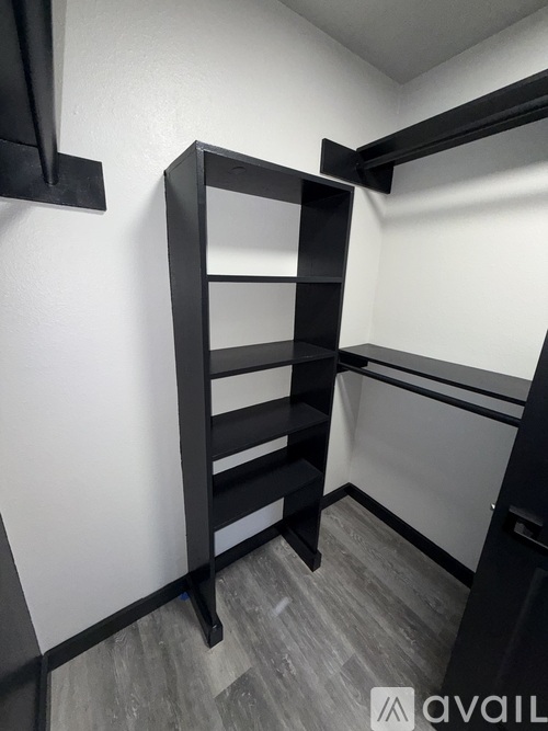 A tall black shelf unit in a room with white walls.