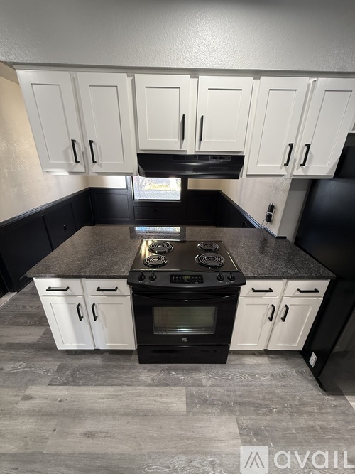 A kitchen with black countertops and white cabinets.
