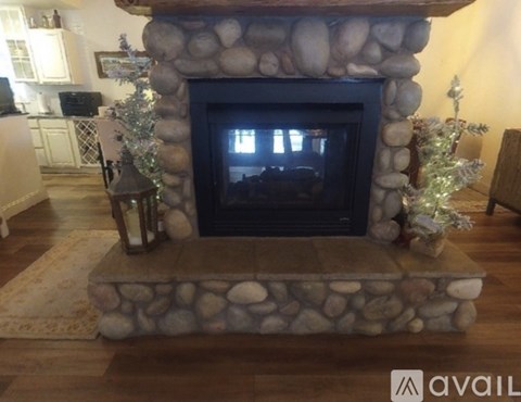 A stone fireplace with a lit candle on the hearth.