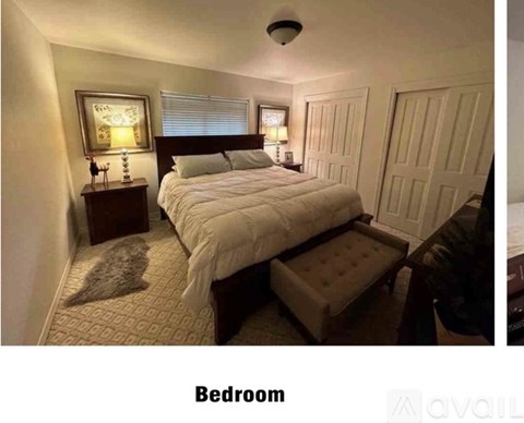 A bedroom with a bed, nightstands, and a window.