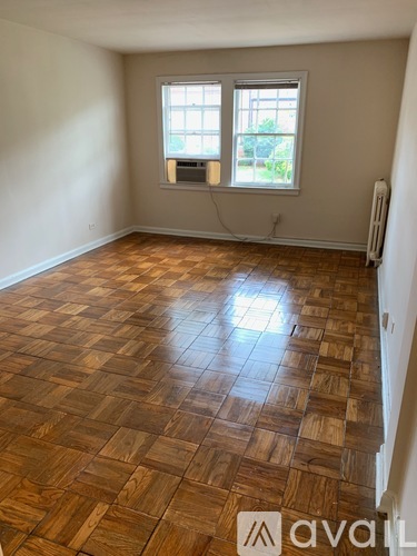 A room with wooden flooring and a window.