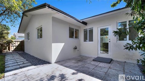 A modern house with a white exterior and a large front yard.