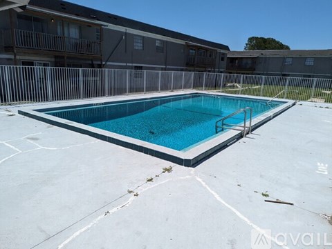 A rectangular pool with a metal fence around it.