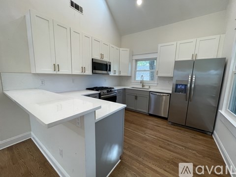 A kitchen with white cabinets and a white counter top.