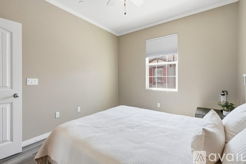 A bedroom with a large bed and a window.
