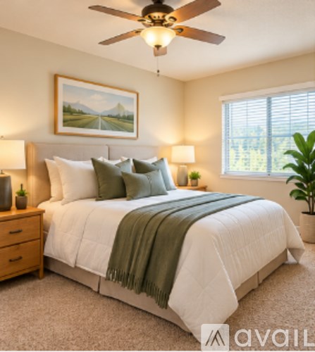 A bedroom with a large bed and a ceiling fan.